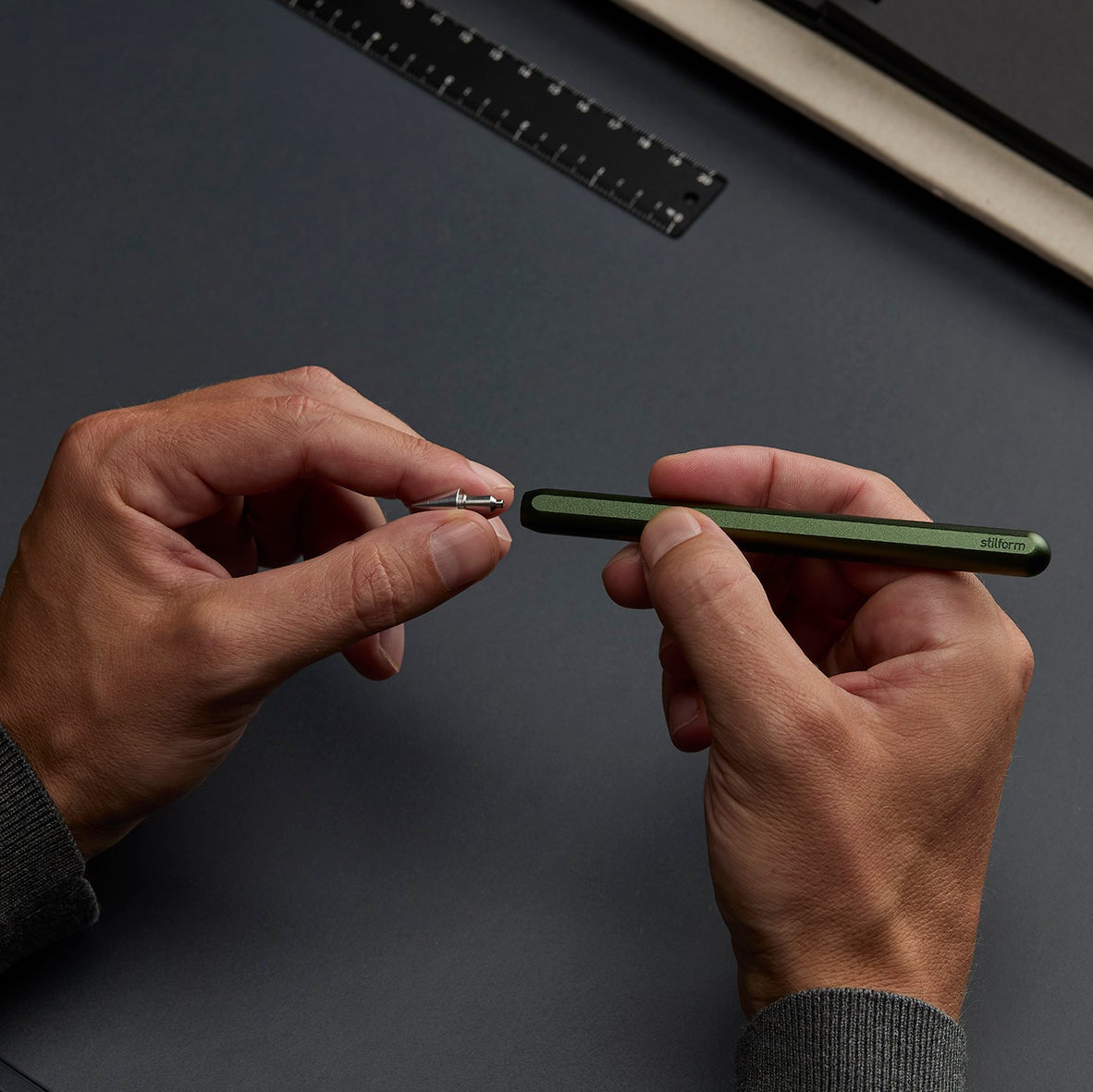Bleistift AEON Pure Aluminium in Aurora Green und Eternal Spitze gehalten in beiden Händen