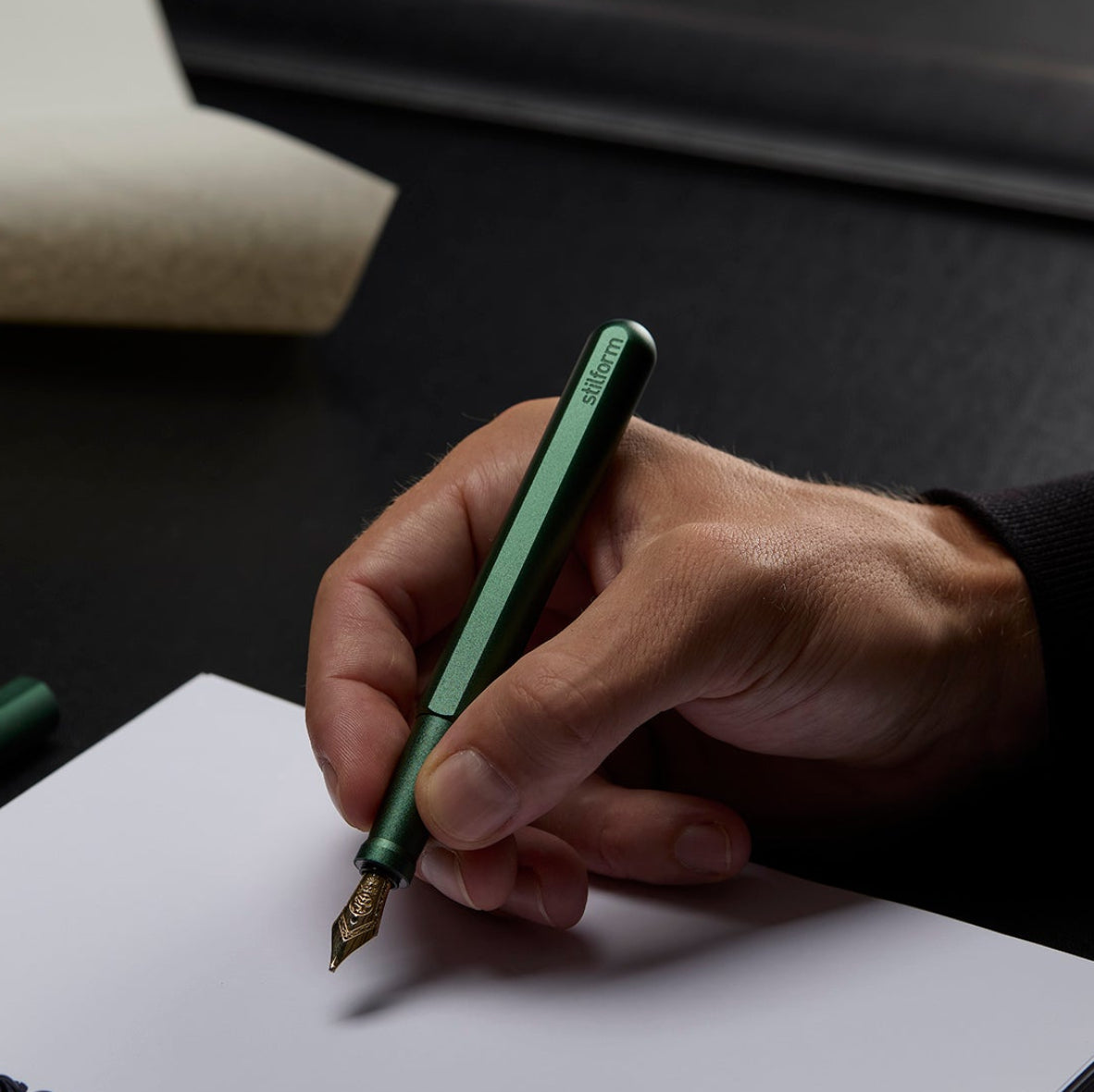Füllfederhalter INK in Aurora Green mit 14 Karat Goldfeder beim Schreiben auf weißem Papier